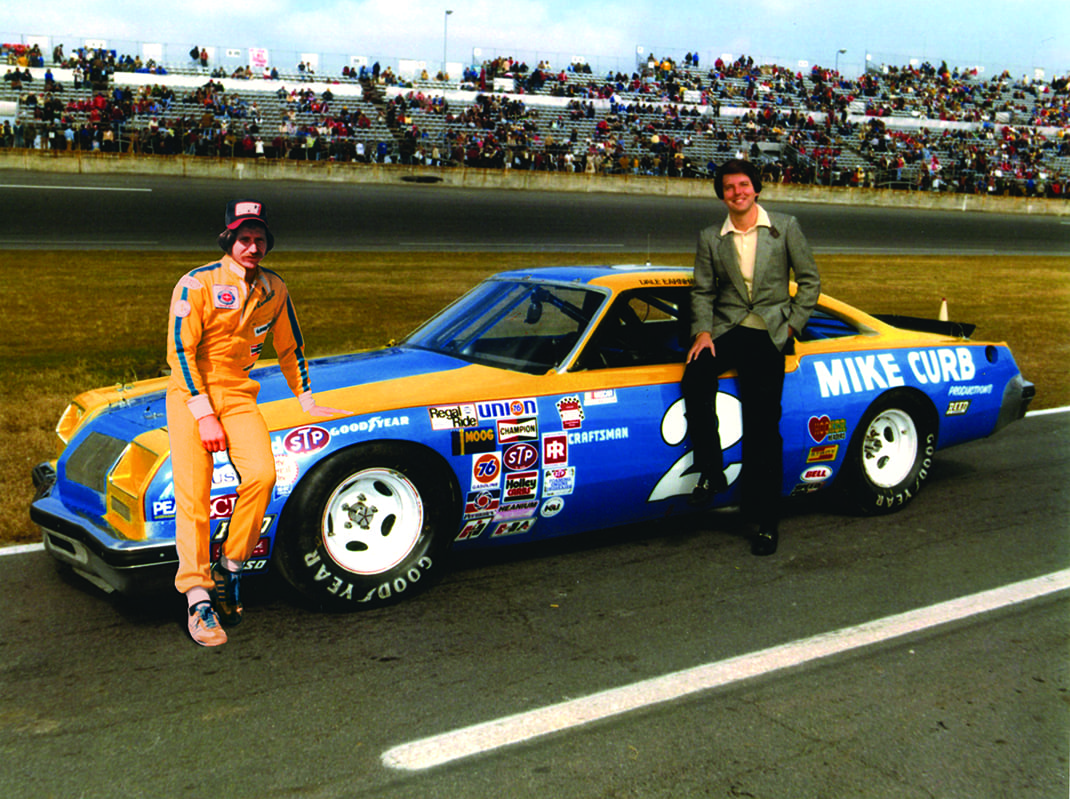 Dale Earnhardt (left) won the 1980 NASCAR Cup Series title with support from Mike Curb (right).