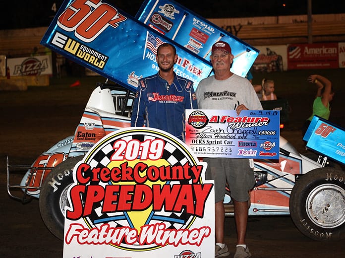 Zach Chappell shares victory lane with his father, David, after winning Saturday night at Creek County Speedway. (Richard Bales Photo)
