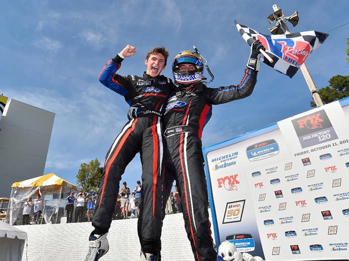 Seb Priaulx (left) and Austin Cindric celebrate after a victory in Friday's IMSA Michelin Pilot Challenge event at Michelin Raceway Road Atlanta. (IMSA Photo)