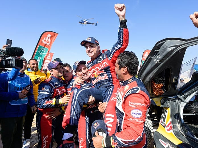 Carlos Sainz gets lifted in the air after clinching his third Dakar Rally title. (Dakar Rally Photo)