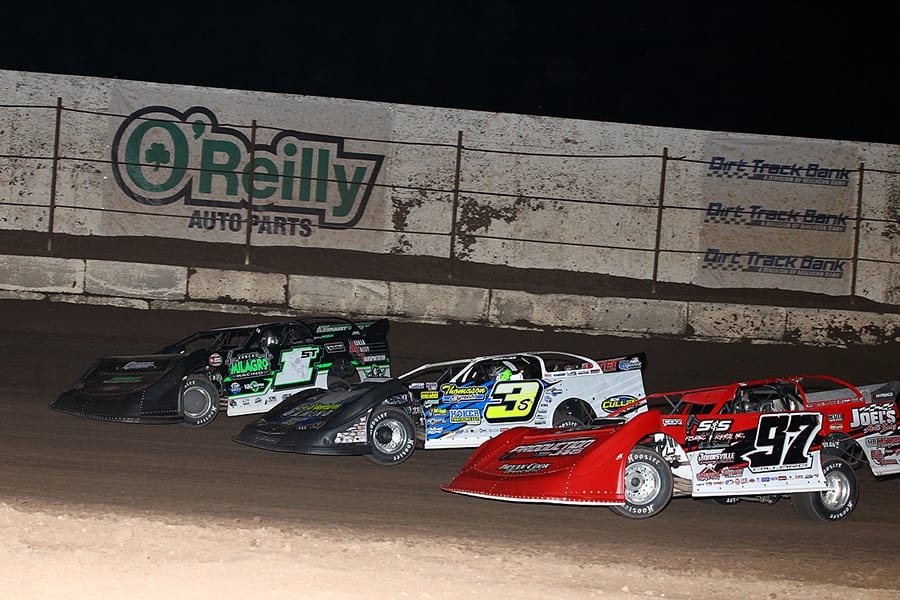 Cade Dillard (97), Brian Shirley (3s) and Johnny Scott race three-wide during Saturday's Wild West Shootout main event at Arizona Speedway. (Mike Ruefer Photo)