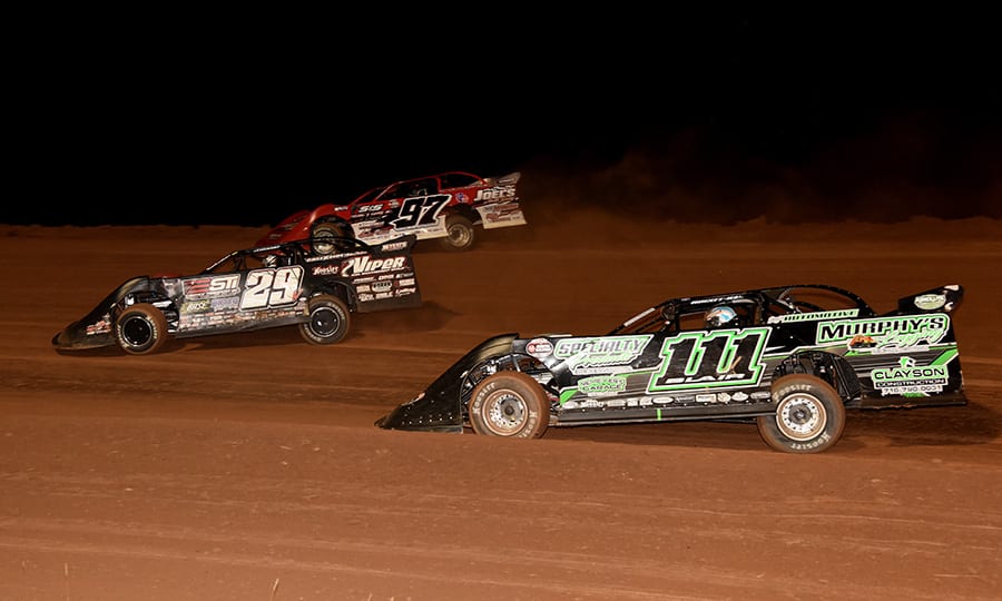 Darrell Lanigan (29), Cade Dillard (97) and Max Blair battle for the race lead during Saturday's Firecracker 100 finale at Lernerville Speedway. (Paul Arch Photo)