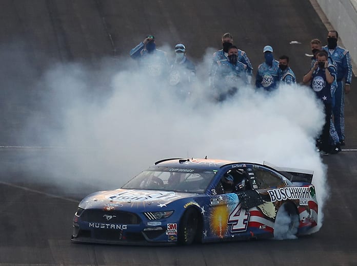 Kevin Harvick celebrates with a burnout as his crew looks on following his victory in the Big Machine Hand Sanitizer 400 Sunday at Indianapolis Motor Speedway. (Jamie Squire/Getty Images Photo)