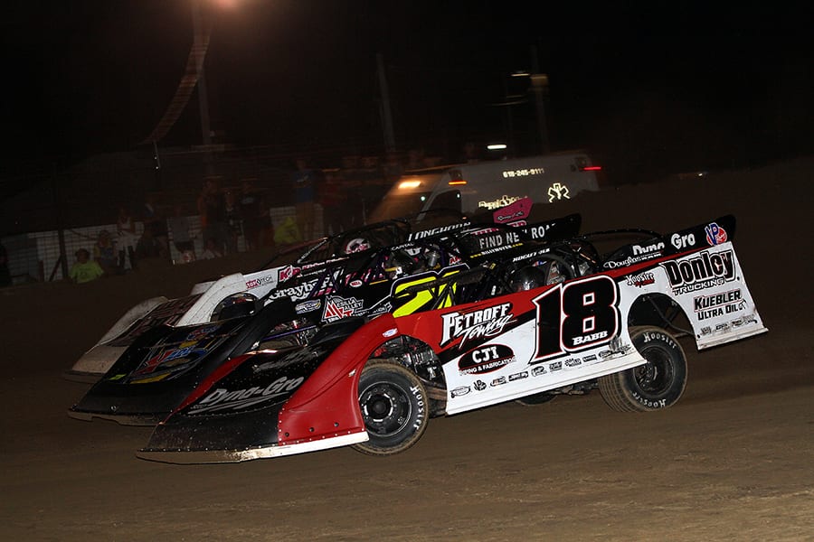 Shannon Babb (18), Billy Moyer (21) and Bob Gardner battle three-wide during Friday's DIRTcar Summer Nationals feature at Fayette County Speedway. (Jim Denhamer Photo)