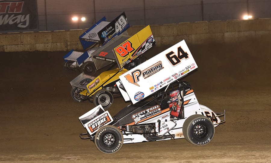 Scotty Thiel (64), Max Stambaugh (97) and Shawn Dancer race three-wide during Thursday's World of Outlaws NOS Energy Drink Sprint Car Series event at Plymouth Speedway. (Paul Arch Photo)