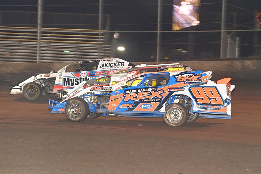 Rocky Caudle (99) and Cam Reimers (21) split another car during Northern sportmod action Wednesday at the IMCA Super Nationals at Boone Speedway. (Tom Macht Photo)