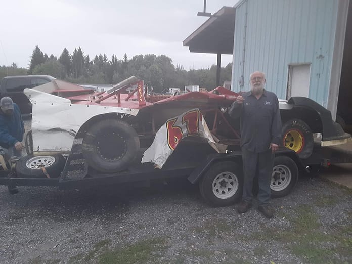 Raymond Reynolds stands beside his totaled street stock following a crash Saturday at Hidden Valley Speedway.