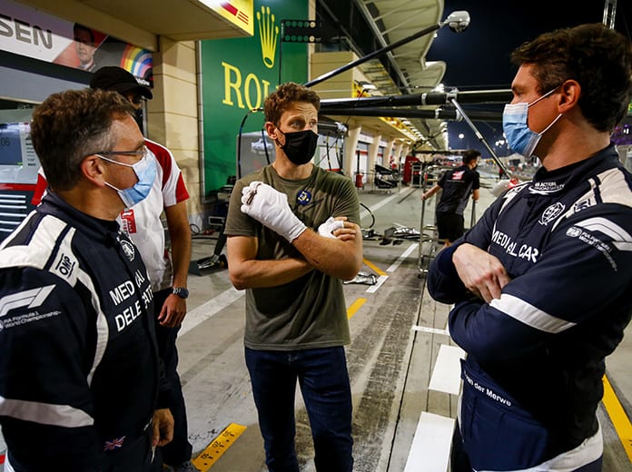 Romain Grosjean (center) talks with Dr. Ian Roberts (left) and Alan van der Merwe, who helped pull him from the flames after last Sunday's violent crash in Bahrain. (Andy Hone/LAT Images Photo)