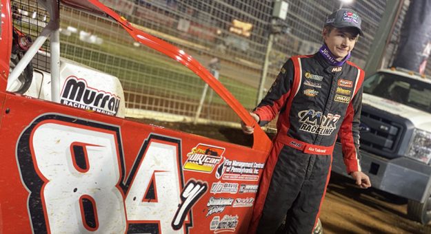 Alex Yankowski poses beside his race car after his win Friday night at The Dirt Track at Charlotte. (Kyle McFadden Photo)