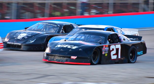 Matt Gould (27) is on the inside of a three-wide battle for position during the Battle of the Stars at Goodyear All American Speedway in November. (Eric Creel Photo)