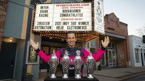 Helio Castroneves stands in front of the Tryon Theater with his four Baby Borg trophies. (Logan Whitton Photography)