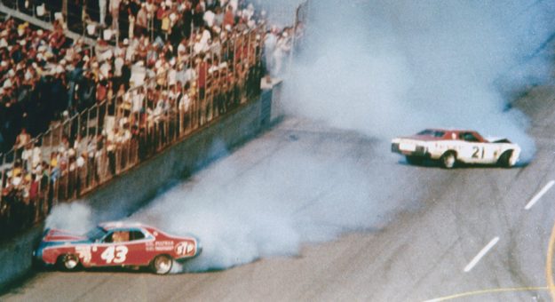 David Pearson and Richard Petty crashed together while racing for th lead on the final lap of the 1976 Daytona 500. Pearson would limp his car across the finish line to win the race. (RacingOne/Getty Images)