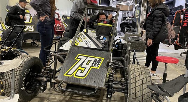 Cruz Pedregon gets fitted into the seat of his No. 79M midget Friday at the Lucas Oil Chili Bowl Nationals. (Adam Fenwick Photo)