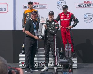 Randy Edeker, CEO of HyVee presents the winner’s trophy to Josef Newgarden as Pato O’Ward and Will Power look on at the HyVeeDeals.com 250 presented by DoorDash at Iowa Speedway in Newton, Iowa.