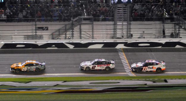 Christopher Bell (20) leads Austin Cindric (2) and Denny Hamlin across the finish line at Daytona Int'l Speedway.