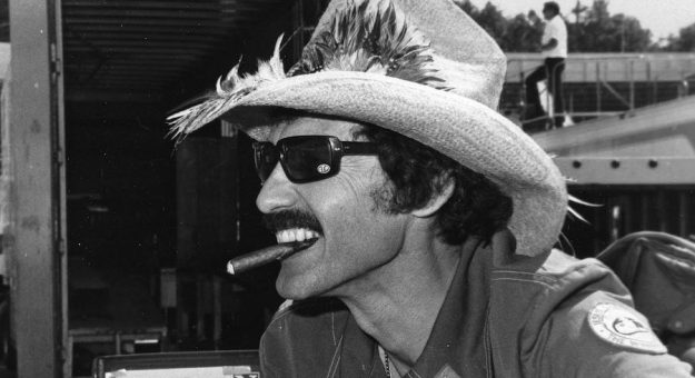 UNKNOWN — Early 1980s:  The “King” of NASCAR Cup racing, Richard Petty, with his ever-present hat and cigar at a Cup race.  (Photo by ISC Images & Archives via Getty Images)